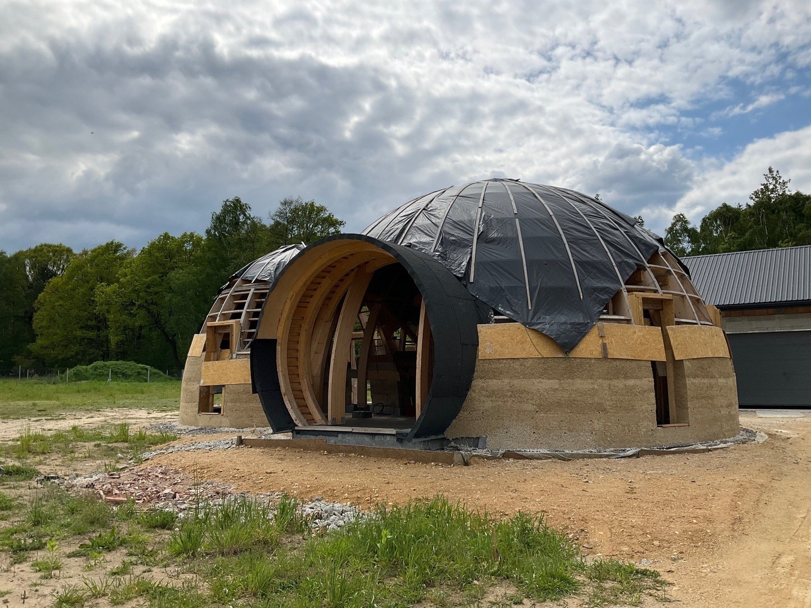 Budowa domu kopułowego z drewnianą konstrukcją i naturalnym wypełnieniem